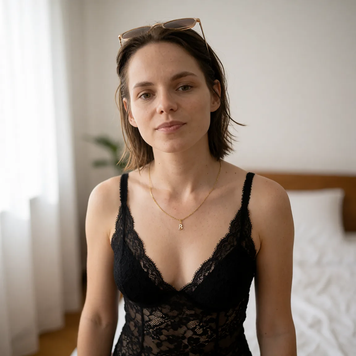 Edit the supplied photograph. Change only what is asked for below. Return one clean, natural, high-resolution photograph with realistic skin texture and no distortion. Replace her outfit with a black lace lingerie set that fits her properly. Keep her face, her identity, her hair and her skin tone exactly as they are, and keep the room and the light she is in. Keep her pose and the framing of the shot.