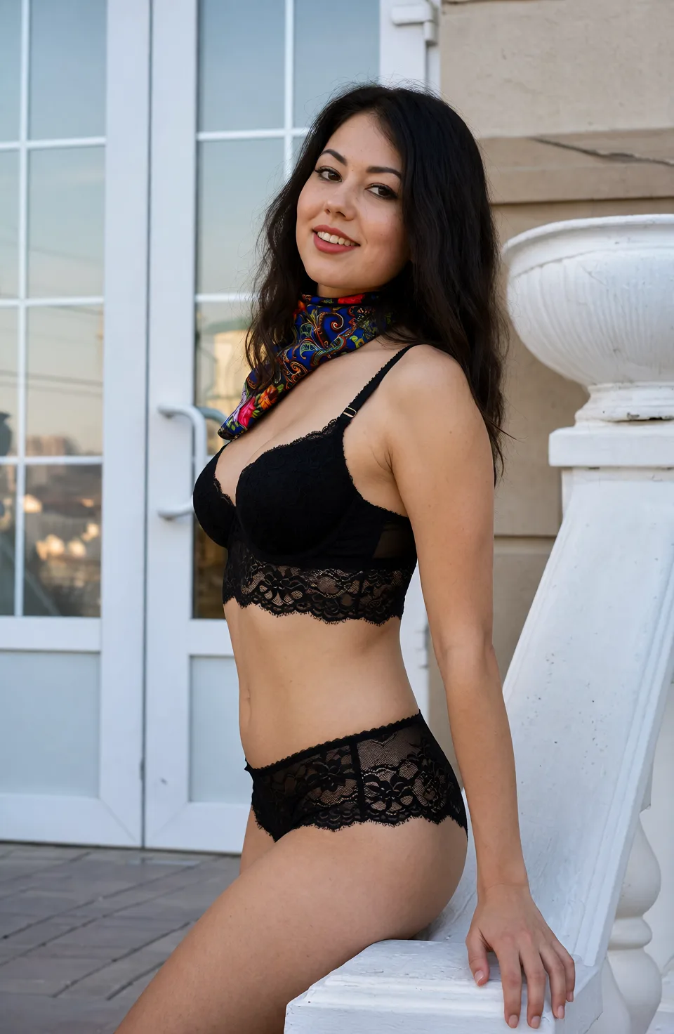 Edit the supplied photograph. Change only what is asked for below. Return one clean, natural, high-resolution photograph with realistic skin texture and no distortion. Replace her outfit with a black lace lingerie set that fits her properly. Keep her face, her identity, her hair and her skin tone exactly as they are, and keep the room and the light she is in. Keep her pose and the framing of the shot.
