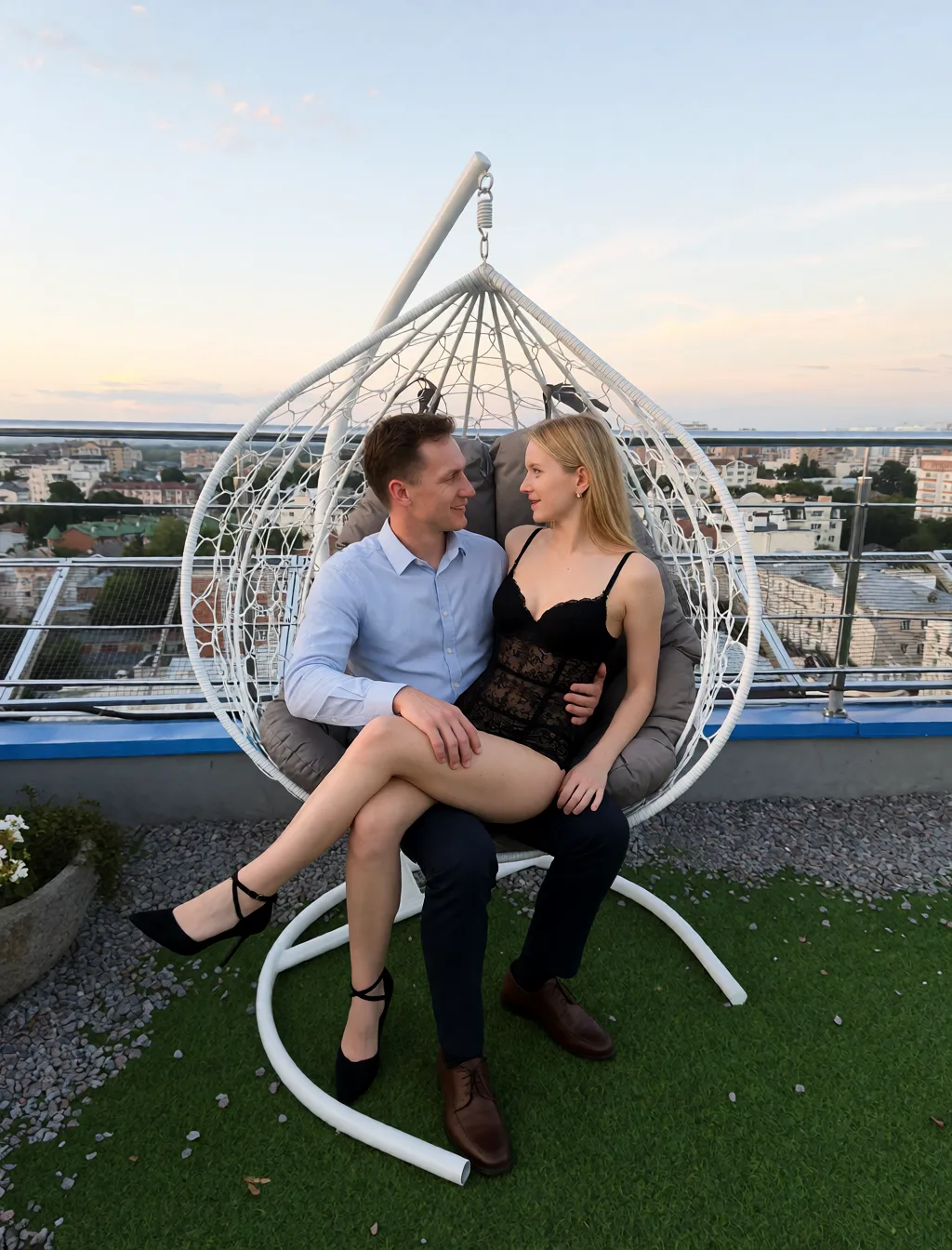 Edit the supplied photograph. Change only what is asked for below. Return one clean, natural, high-resolution photograph with realistic skin texture and no distortion. Replace her outfit with a black lace lingerie set that fits her properly. Seat her turned towards a partner whose hand rests on her upper thigh over what she is wearing; the partner wears an ordinary shirt and trousers. Keep her face, her identity, her hair and her skin tone exactly as they are, and keep the room and the light she is in.