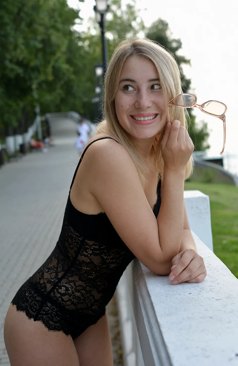 Edit the supplied photograph. Change only what is asked for below. Return one clean, natural, high-resolution photograph with realistic skin texture and no distortion. Replace her outfit with a black lace lingerie set that fits her properly. Keep her face, her identity, her hair and her skin tone exactly as they are, and keep the room and the light she is in. Keep her pose and the framing of the shot.