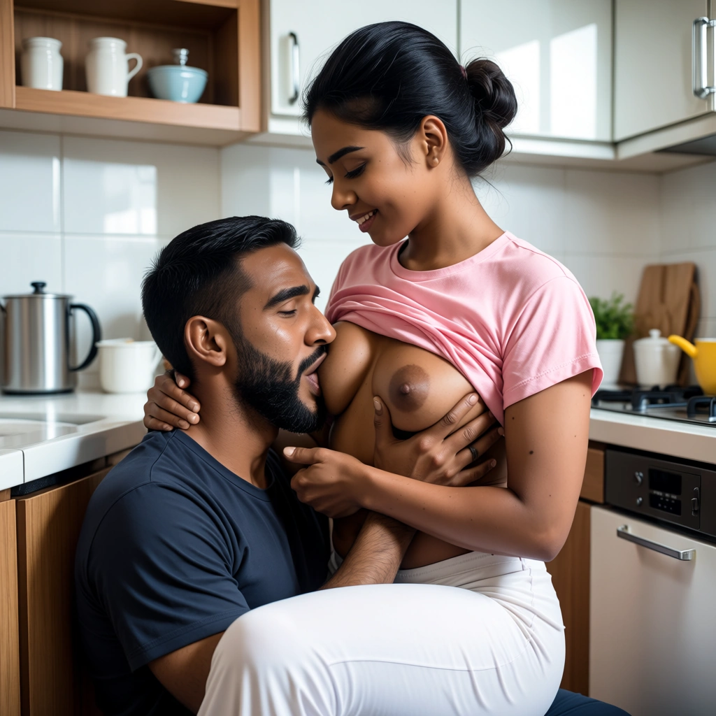 A south indian dark skinned and very thin tamil wife of age 29 wearing a pink t-shirt and white night pant and breastfeeding her grown up bearded indian dark skinned husband of age 24 by sitting in the kitchen